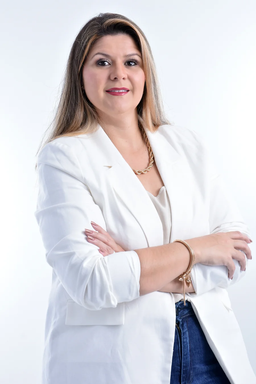 Bruna Cassaro de blazer branco em postura de autoridade